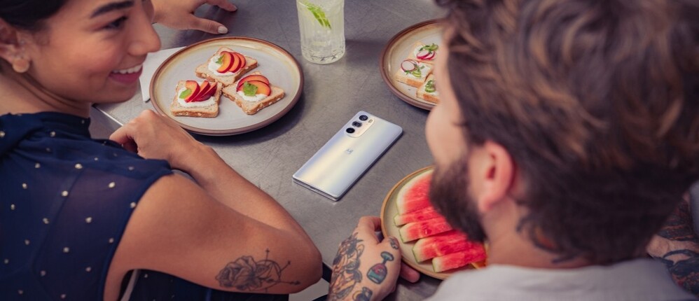 Nem tudom, hogy finom-e a barackos kenyér, de ezen a képen azt eszi valaki a Motorola Edge 30 Pro mellett balra.