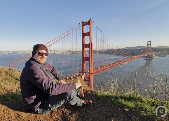 Rögtönzött, egész alakos kép a Golden Gate hídnál, szikrázó napfényben