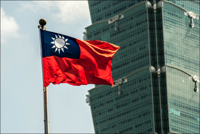 Tajvan zászlaja, háttérben a Taipei 101 épületével.